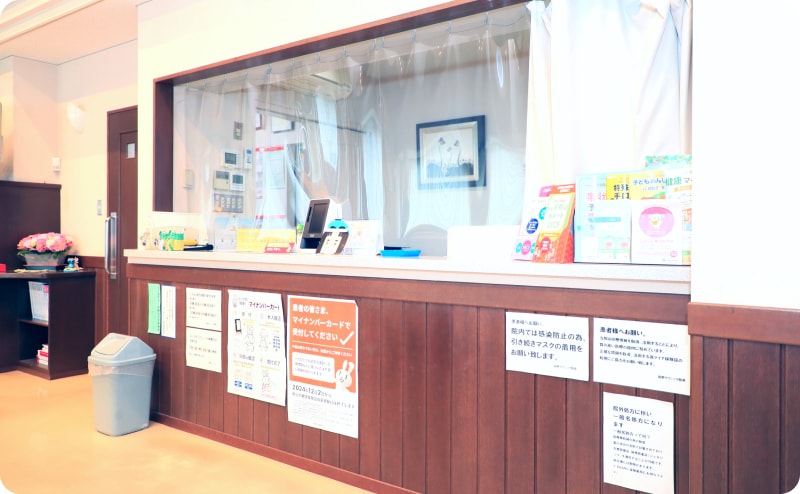 木目調の受付カウンターがあるクリニックの待合室の一角