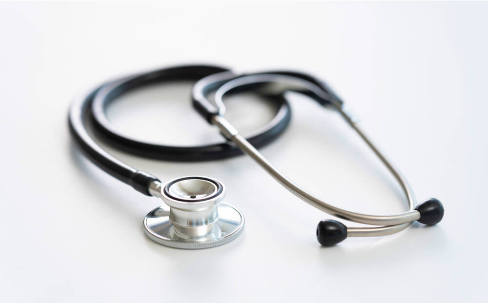 シルバーと黒の聴診器が白い背景の上に置かれている